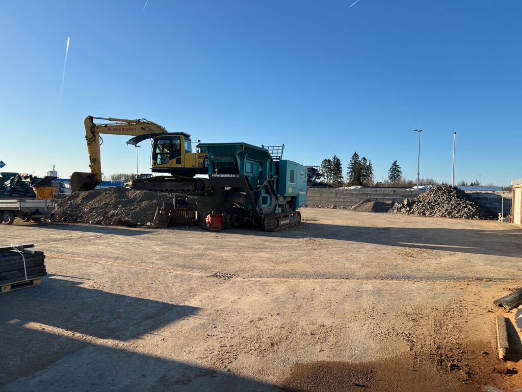 Bagger befüllt Brecheranlage